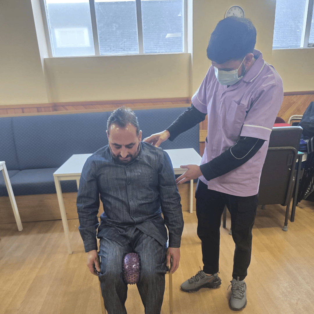 Thumhara volunteer assisting with chair exercises